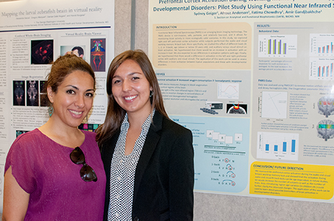 Sydney Geiger ’18 (right) and National Institutes of Health biomedical engineer Afrouz Anderson stand in front of a poster describing the research they worked on together using emerging brain imaging technology.
